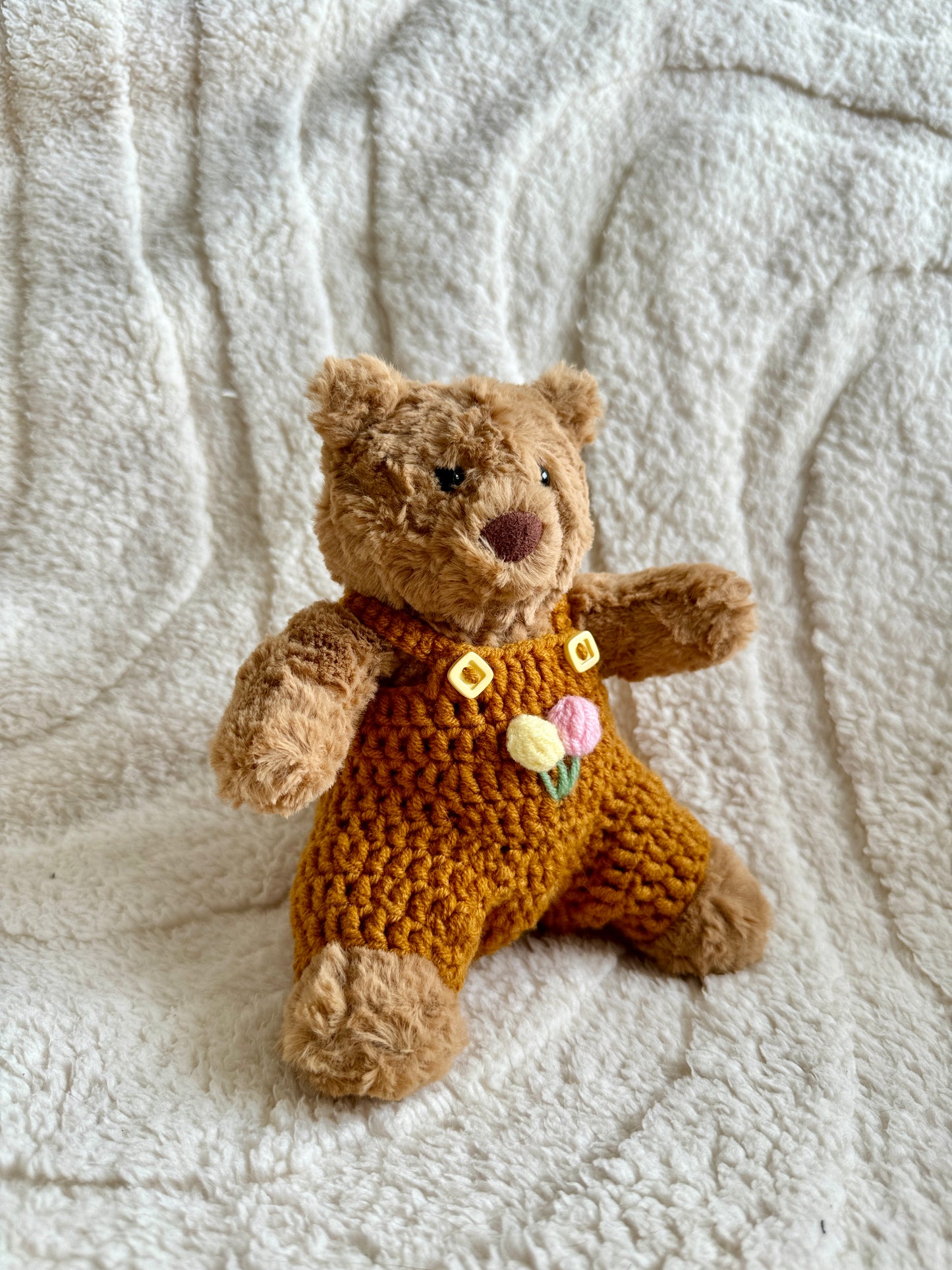 Side view of the pumpkin romper showing yellow button details and soft textured finish.