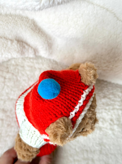 Close-up of blue pom-pom and striped hood on handmade knit onesie for Jellycat Bartholomew