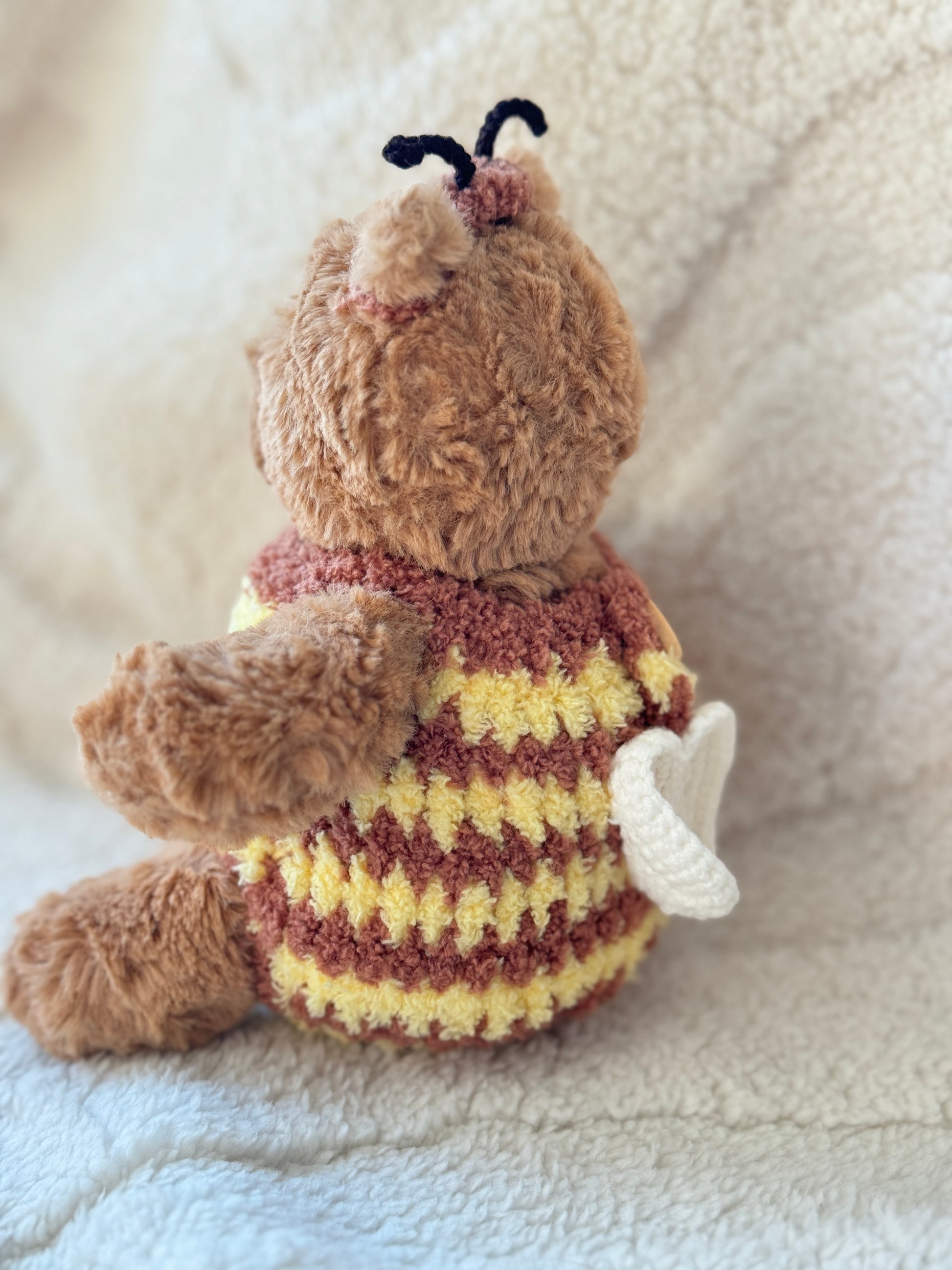 Cute Jellycat Bart bear dressed in a handmade crochet bumble bee outfit inspired by wildflowers and cottage garden aesthetics.