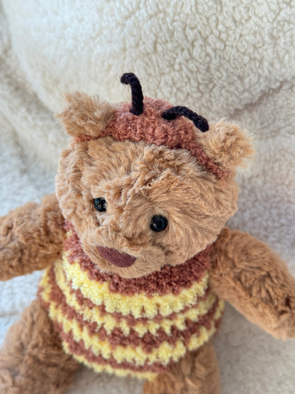 Close-up of Jellycat Bartholomew Bear in a fluffy bumble bee costume with tiny black antennae and textured crochet details.