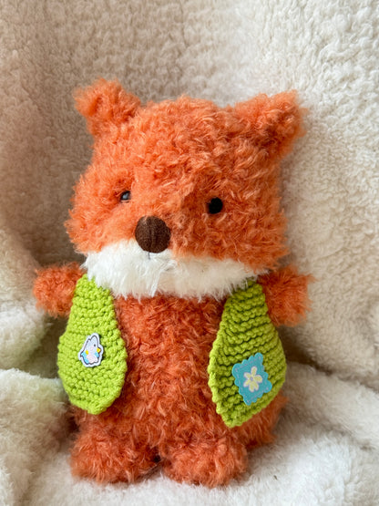 Little Fox dressed in a green crochet vest for plush styling and display