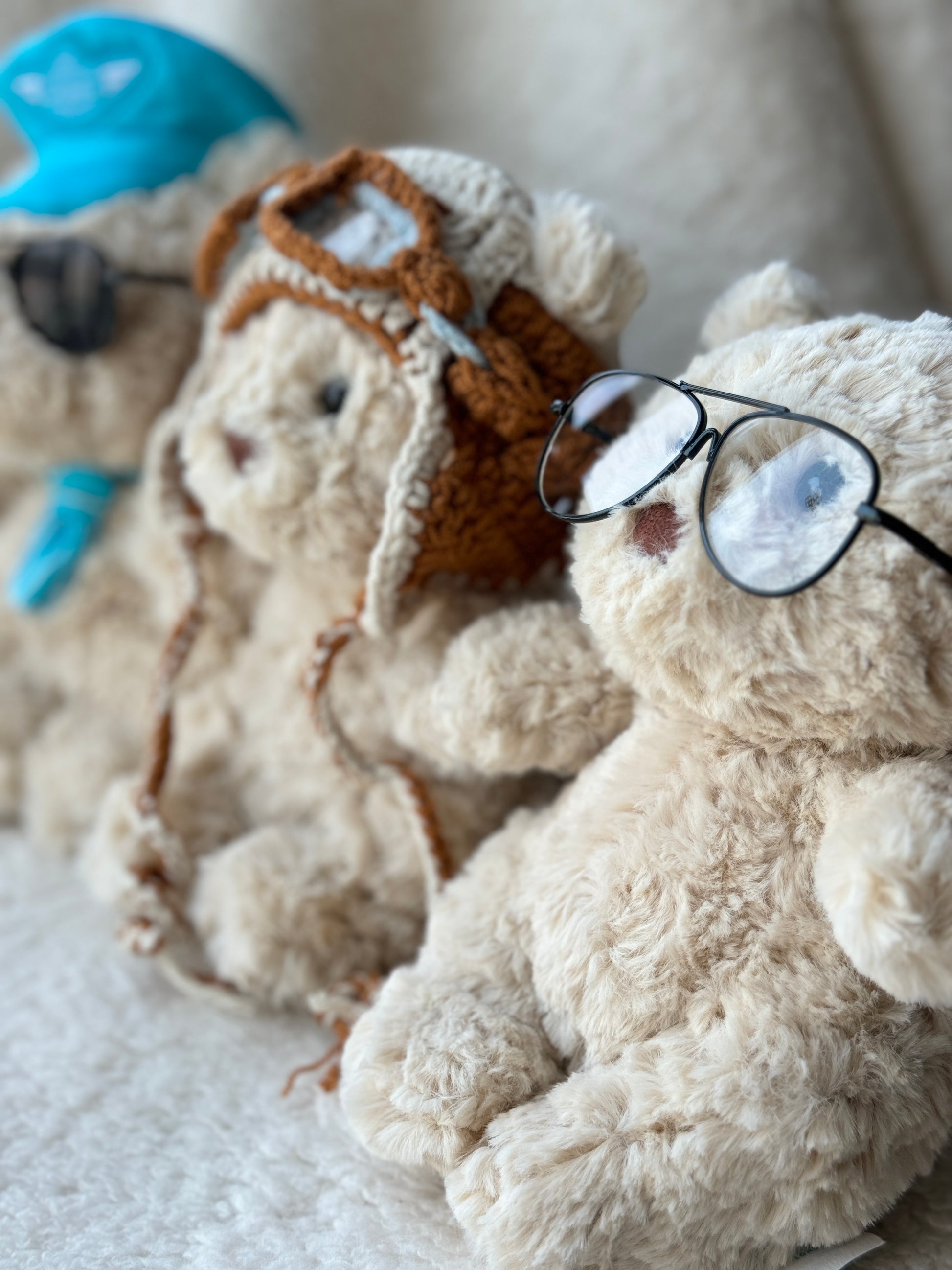 Three Jellycat Bartholomew Bear plush styled with glasses and pilot accessories