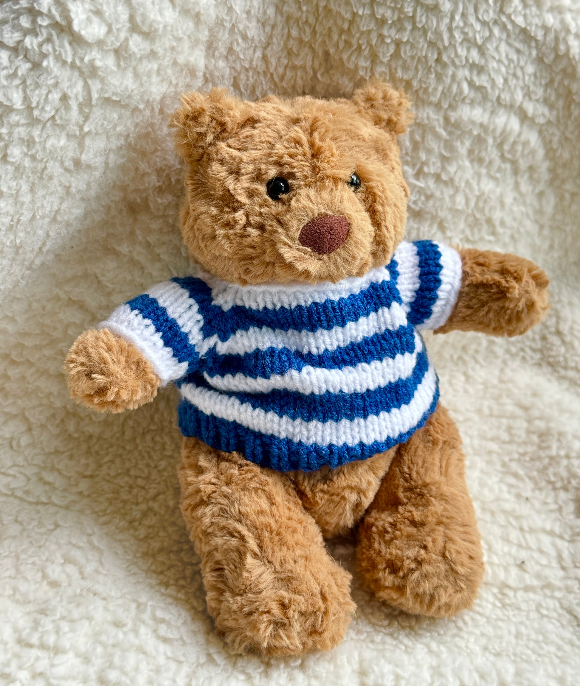 Jellycat Bartholomew Bear dressed in a handmade navy blue sailor sweater with classic white stripes and coastal summer aesthetic.
