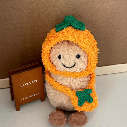 A Jellycat Amuseables plush dressed in a handmade crochet orange outfit, featuring a vibrant orange hood with a green leafy top and a matching bag.
